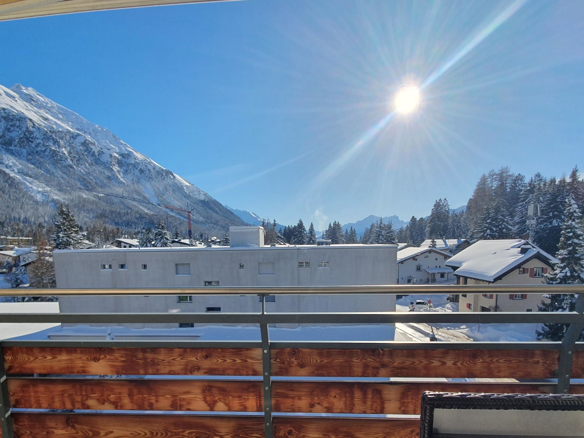 A mountain landscape with a building and snow-covered trees.