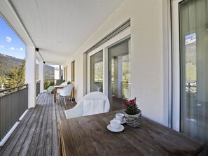 A wooden deck with a table and chairs, overlooking a mountainous landscape. - Liebrand Appartement/Fewo Ferienwohnung Liebrand by Interhome (Churwalden)