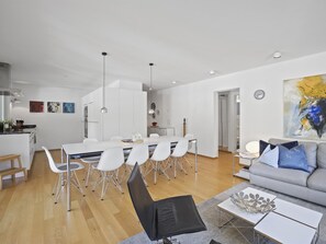 En moderne opholdsstue med spiseplads, sofa og sofabord.