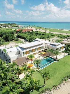 A modern resort with a pool, beachfront view, and multiple buildings.