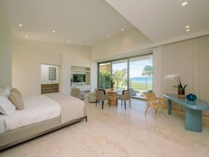 Ein Schlafzimmer mit einem Bett, einem Schreibtisch und Blick aufs Meer.