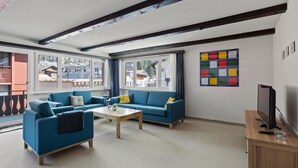 Ein Wohnzimmer mit zwei Sofas, einem Couchtisch und einer TV-Konsole.