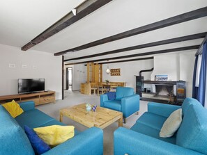 A living room with blue sofas, a wooden coffee table, and a television. - Seeli Appartement/Fewo,   Ferienwohnung Seeli by Interhome (Churwalden)