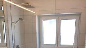 A modern bathroom with a shower, a window, and a toilet. - Haus Allod 201 Appartement/Fewo Allod 201 Gretler by Interhome (Lenzerheide)