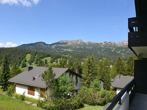 Un quartier résidentiel où les maisons sont entourées de verdure et où l’on aperçoit des montagnes au loin.