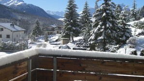 A wooden deck with a bench, overlooking a snowy landscape with houses and mountains. - La Schmetta 11 Appartement/Fewo 5 Bettwohnung IH/ED by Interhome (Lenzerheide)