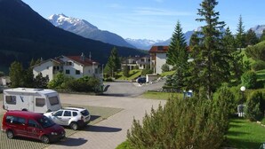 A residential area with houses, a parking lot, and mountains in the background. - La Schmetta 11 Appartement/Fewo 5 Bettwohnung IH/ED by Interhome (Lenzerheide)