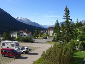 A residential area with houses, a parking lot, and mountains in the background. - La Schmetta 11 Appartement/Fewo 5 Bettwohnung IH/ED by Interhome (Lenzerheide)