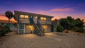 A two-story house with a front porch, a staircase, and a garage. - Walk To Beach, North End Restaurants, Night Life Steps Away! (Fort Myers Beach)