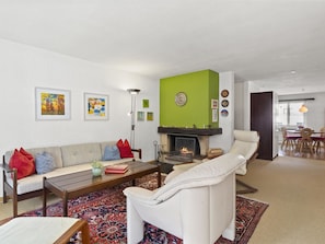 A living room with a sofa, armchair, coffee table, fireplace, and artwork on the wall. - Lang Appartement/Fewo,   Ferienwohnung Lang by Interhome (Churwalden)