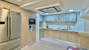 Una cocina moderna con microondas integrado, horno y refrigerador de acero inoxidable.