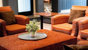 Een zithoek met oranje gestreepte banken en een kleine tafel met een plant.