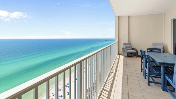 Ein Balkon mit Blick auf das Meer, ein Tisch, Stühle und eine kleine Sitzecke.