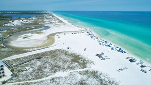 An aerial view of a beach with a curved road, a sandy beach, and a clear blue ocean. - Luxury, Blue Eden Bliss Sleeps 12, Close to Bay (Santa Rosa Beach)