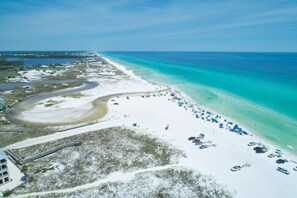 An aerial view of a beach with a curved road, a sandy beach, and a clear blue ocean. - Luxury, Blue Eden Bliss Sleeps 12, Close to Bay (Santa Rosa Beach)