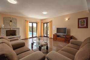 Ein Wohnzimmer mit Kamin, Fernseher und einer Couch.