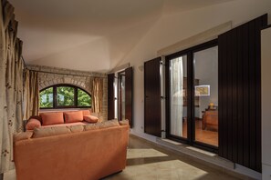 Ein Schlafzimmer mit Schlafsofa, einem Vorhangfenster und Blick ins Freie.