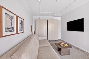 A modern living room with a sofa, a coffee table, and a flat-screen TV mounted on the wall. - Domaine De Cocagne N°2 - Pool & Sea View, Cagnes sur Mer, France (Cagnes sur Mer)