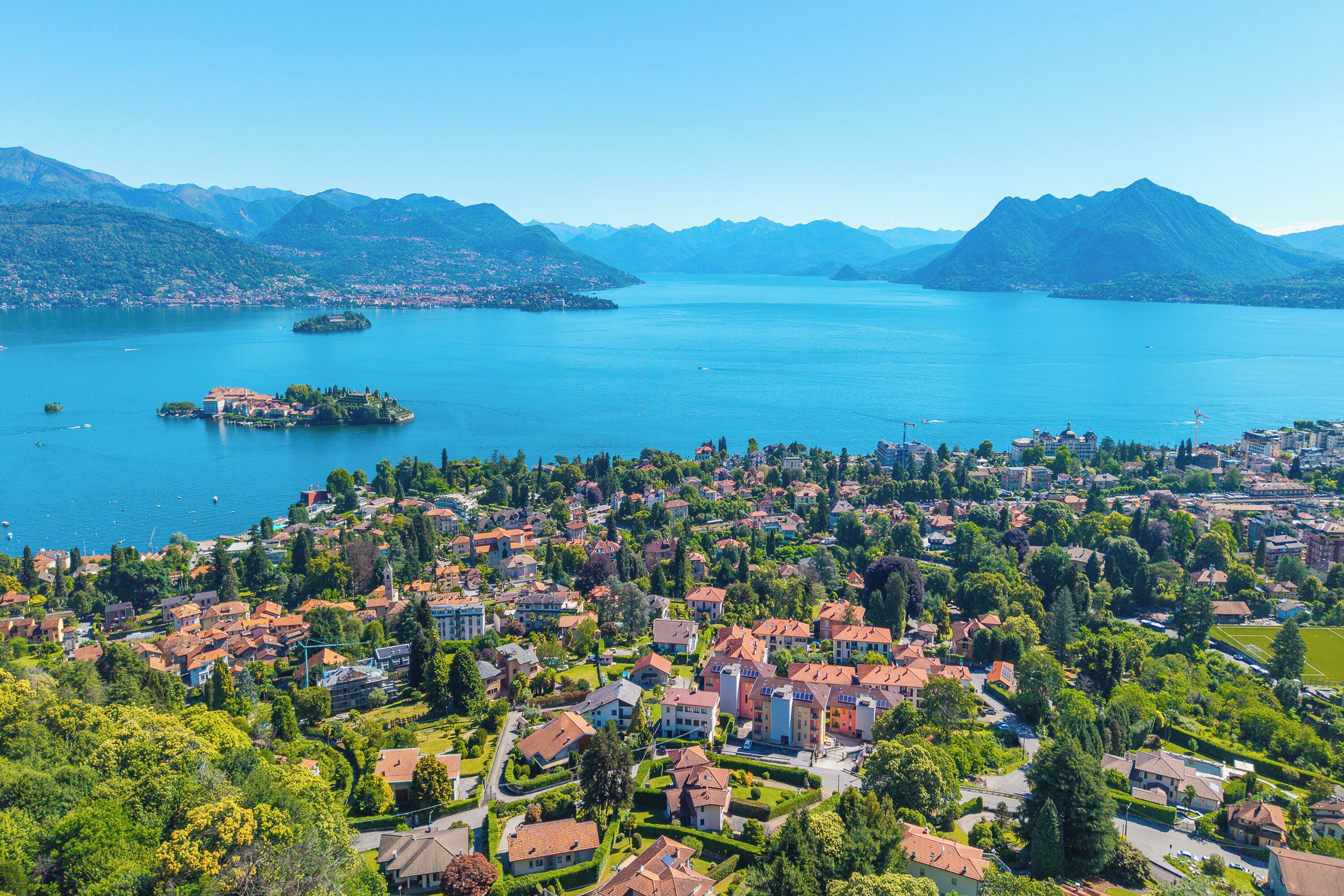 Un pueblo costero con un lago, montañas y edificios residenciales.