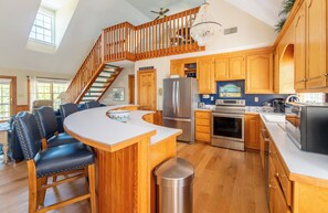 A spacious kitchen with wooden cabinets, a stainless steel refrigerator, and a built-in oven. - The Virginian at Duck - Sound Sea Village, Sound Views, Private Dock, Pets OK, Flex Stays (Duck)