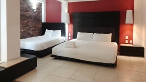 Een hotelkamer met twee bedden, een bakstenen muur en een rode accentmuur.