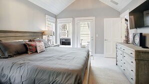 A bedroom with a bed, dresser, and a TV on the wall. - Downtown Breckenridge retreat with mountain views, fireplace, hot tub. (Breckenridge)