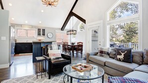 A spacious living area with a sofa, coffee table, and a dining area with chairs. - Downtown Breckenridge retreat with mountain views, fireplace, hot tub. (Breckenridge)