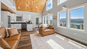 Un amplio espacio habitable con techo alto, ventanas grandes y vistas al exterior.