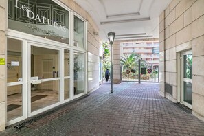 Ein Hotel Eingang mit einem Schild mit der Aufschrift 'Les DATURAS', einem gefliesten Weg und einem Blick auf ein Gebäude im Hintergrund.