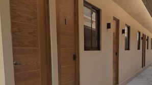A corridor with wooden doors and small windows, leading to individual rooms. - LOFT. 5 Next to CERACOM and 500 m from Plaza Crystal. (Villahermosa)