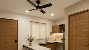 A modern kitchen with a central island, bar stools, a ceiling fan, and wooden cabinetry. - LOFT. 5 Next to CERACOM and 500 m from Plaza Crystal. (Villahermosa)