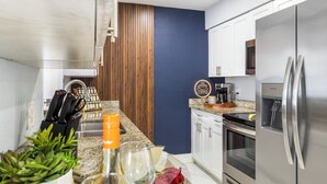 Een moderne keuken met een roestvrijstalen koelkast, een koffieapparaat en een wand bekleed met hout.