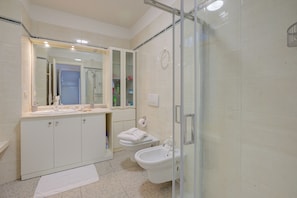 A bathroom with a glass shower enclosure, a sink with a mirror, and a toilet. - Vida Boa Queen Room, Torbole sul Garda, Italy (Torbole sul Garda)