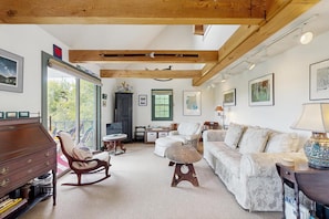 A spacious living room with a wooden ceiling, a sofa set, a rocking chair, and a dining table. - Peaceful mountain home w/ amazing views; close to hiking trails & quaint towns (Franconia)