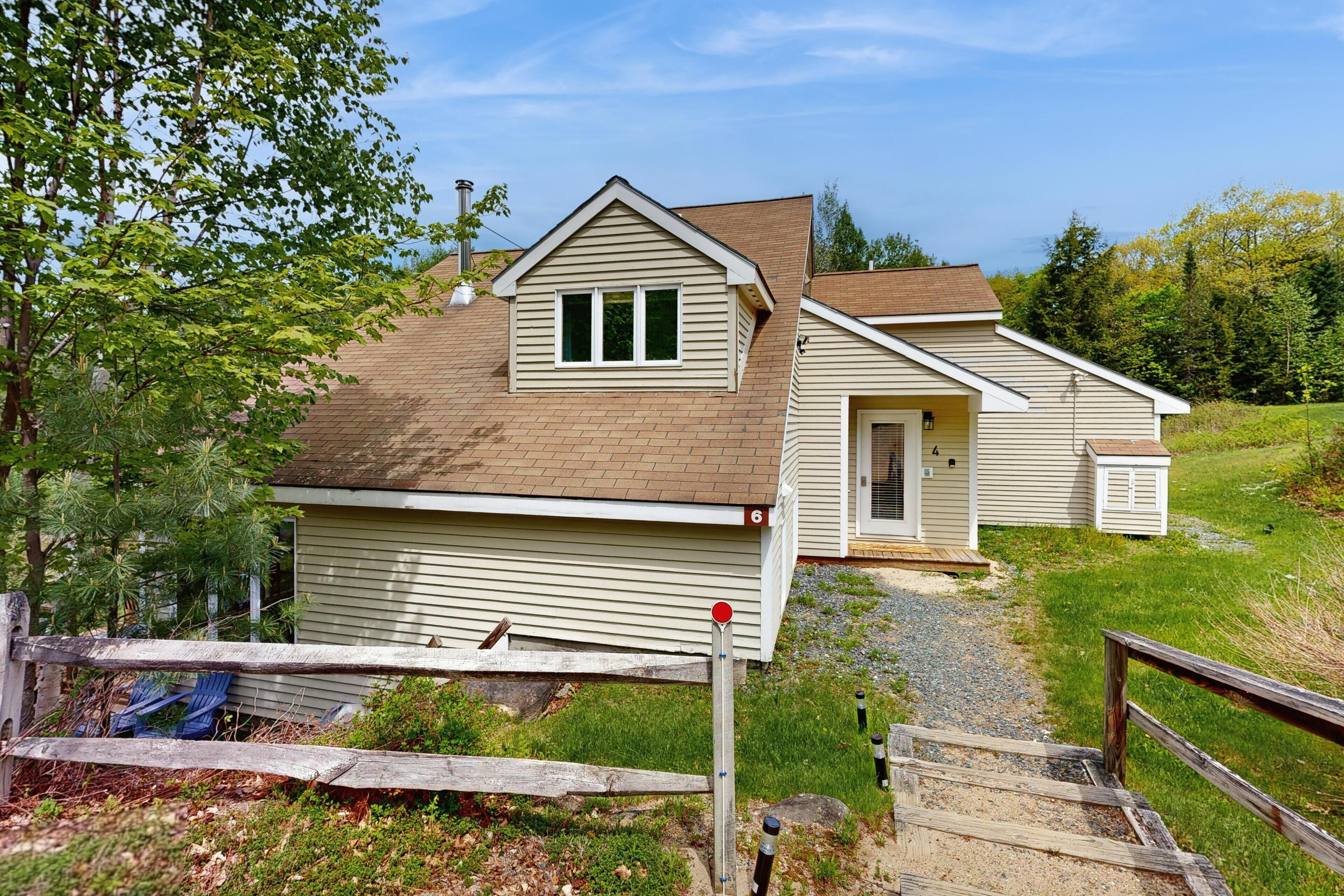 A two-story house with a front porch, a garage, and a small shed.