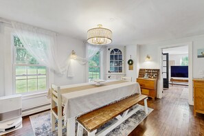 Ein Zimmer mit Bett, Schreibtisch, einer Deckenleuchte und Blick ins Freie.