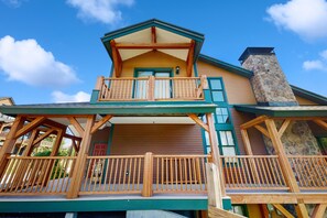 A two-story wooden cabin with a balcony and a stone chimney. - Newly renovated mountainside condo on the access road with two suites (Dover)