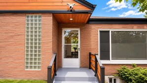 En moderne bygning med facade i mursten, et stort vindue og en dør.