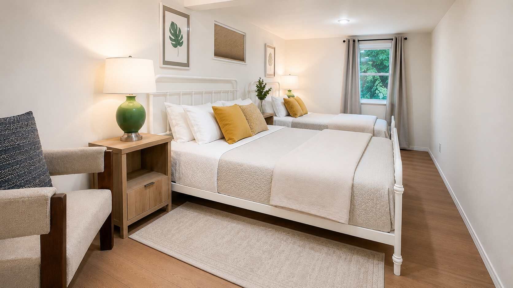 Une chambre à coucher comprenant un lit, des tables de chevet, une chaise, une fenêtre avec des rideaux et une plante fixée au mur.