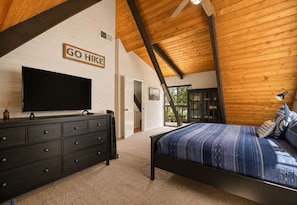 Un dormitorio con una cama, un televisor, un aparador y un cartel que dice 'GO Hike'.