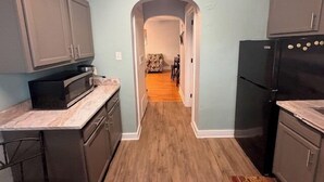A kitchen with cabinets, a microwave, and a refrigerator. - Sherman Hills Historic Retreat #6 (Des Moines)