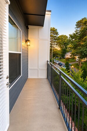 A balcony with a view of a residential street, a light fixture, and a door. - Luxury Belt Line Retreat l Walk to Ponce City Market & Krog Street (Atlanta)