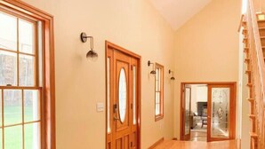 A spacious hallway with wooden flooring, a bench, and a staircase. - Fire Pit Evenings • Outdoor Dining - Five Acres (Palenville)