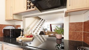 Uma cozinha com fogão embutido, micro-ondas e torradeira.