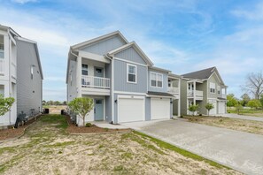 A residential building with a two-story structure, a garage, and a small front yard with trees. - Game Night- Game themed vacation rental (South Haven)