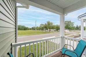 A porch with a view of a street and a grassy area. - Beach Glass Bungalow- new build close to beach and park (South Haven)