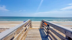 A wooden boardwalk leading to a beach with a clear view of the ocean. - Turtlemound Terrace - Your Favorite Beach Getaway (New Smyrna Beach)