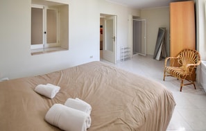 Une chambre à coucher avec un grand lit, une chaise et une armoire.