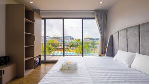 Habitación de hotel con una cama grande, un armario, un balcón con vistas y un diseño moderno.