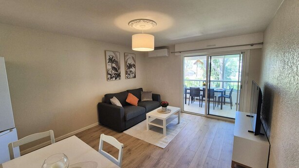 Ein modernes Wohnzimmer mit Sofa, Couchtisch und Essbereich.
